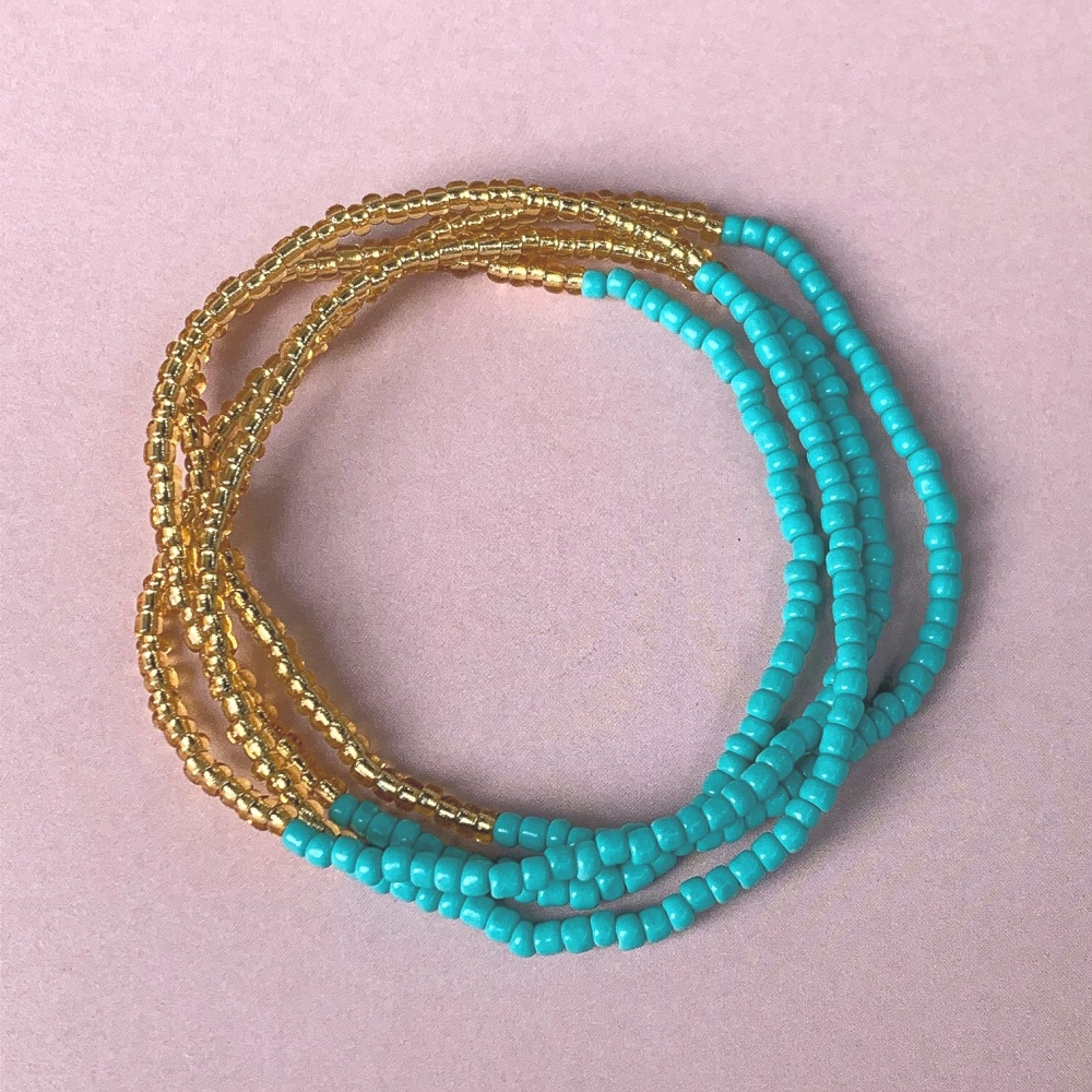 Nydelig kjede med små fargerike dekorative perler. Dette er et multifunksjonelt smykke som kan brukes både som armbånd og som halskjede/choker. Kjedet har en sommerlig kombinasjon av små flotte gullfargede glassperler og herlige turkise perler. 
