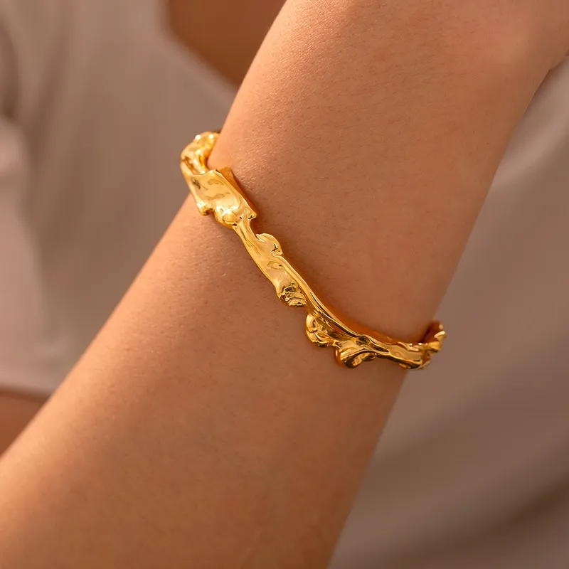 Sarah bracelet er inspirert av naturens flytende former, skaper en moderne og sofistikert stil som løfter enhver antrekk. Perfekt for den som ønsker et tidløst smykke med en unik vri. 18k gullbelagt stål.