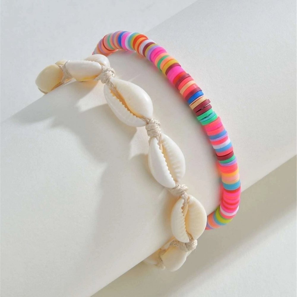 Fullfør looken med vårt sommerlige armbånd-sett Capri fra JBX Accessories. Settet består av 2 ulike armbånd laget av skjell og Heishi-perler. Fargerike sommerarmbånd som passer perfekt til de fleste av sommerens antrekk.