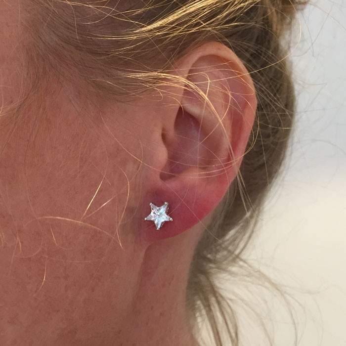 JBX ESSENTIAL CRYSTAL STAR STUD EARRINGS PÅ EN MODELLS ØRE