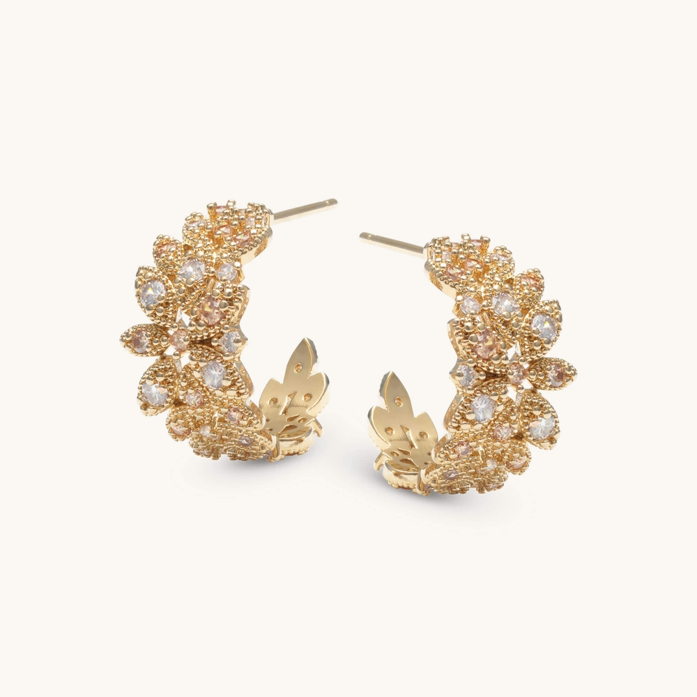 Our Laurel hoops earrings beautifully combines elegance and femininity. Delicate clear and pink stones adorn the gold-plated band, creating a subtle yet captivating sparkle. This timeless accessory is perfect for everyday grace and glamour.