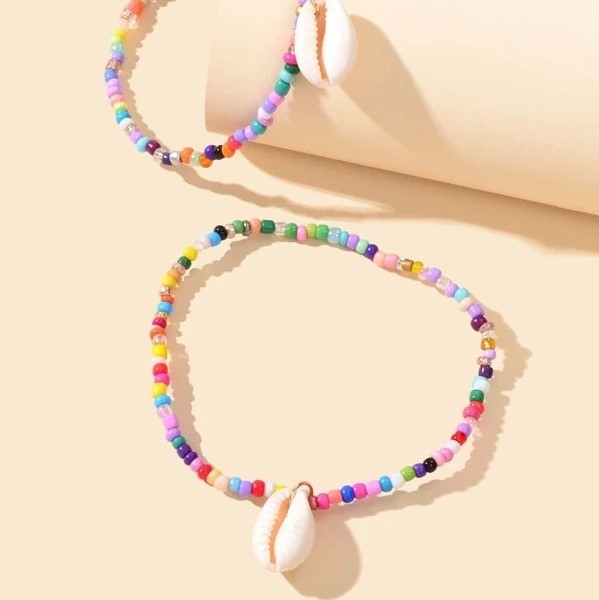 Det ultimate smykke for sommerutseendet ditt! Søt og sommerlig ankelkjede med hvitt skjell og miniperler i alle regnbuens farger. Et lekkert tilbehør til ankelen som utstråler litt boho vibes.