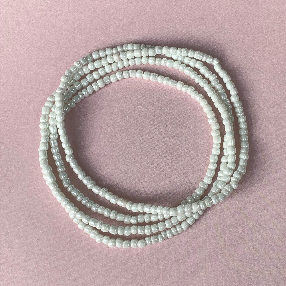 Nydelig kjede med små hvite dekorative perler. Dette er et multifunksjonelt smykke som kan brukes både som armbånd og som halskjede/choker. Sjarmerende Ibiza vil garantert tilføre dine antrekk en feminin og litt bohem-inspirert touch i sommer.