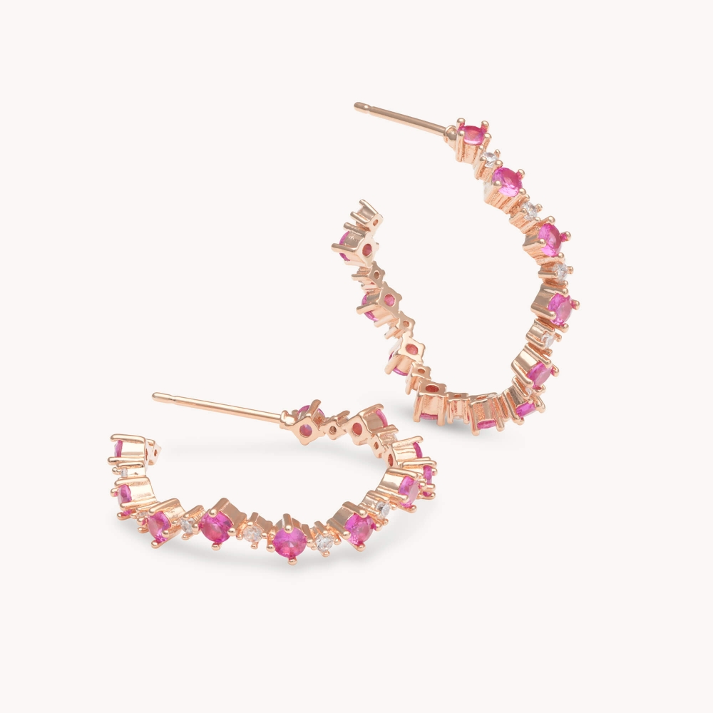 New to the collection the Capella hoop earring is the perfect addition to any look. Set in gold, these earrings bring loads of attention with curved lines that are completely adorned with endless petite runy pink Swarovski cubics. 