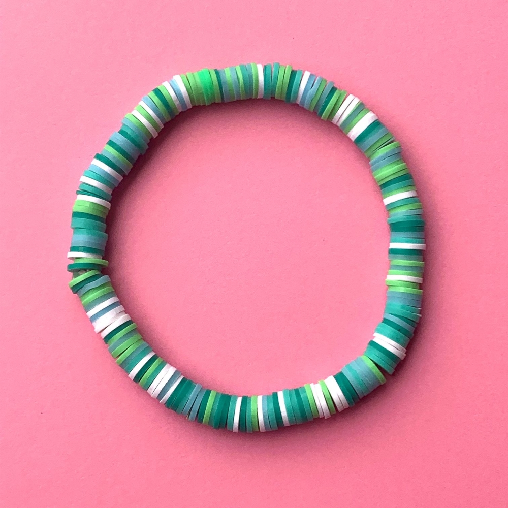 Perfekt sommerarmbånd i surferstil som tåler både vann og solkrem! Perlearmbåndet har en kombinasjon av ulike fargerike vinyl perler i herlige grønne nyanser. Et summer-musthave, spør du oss!