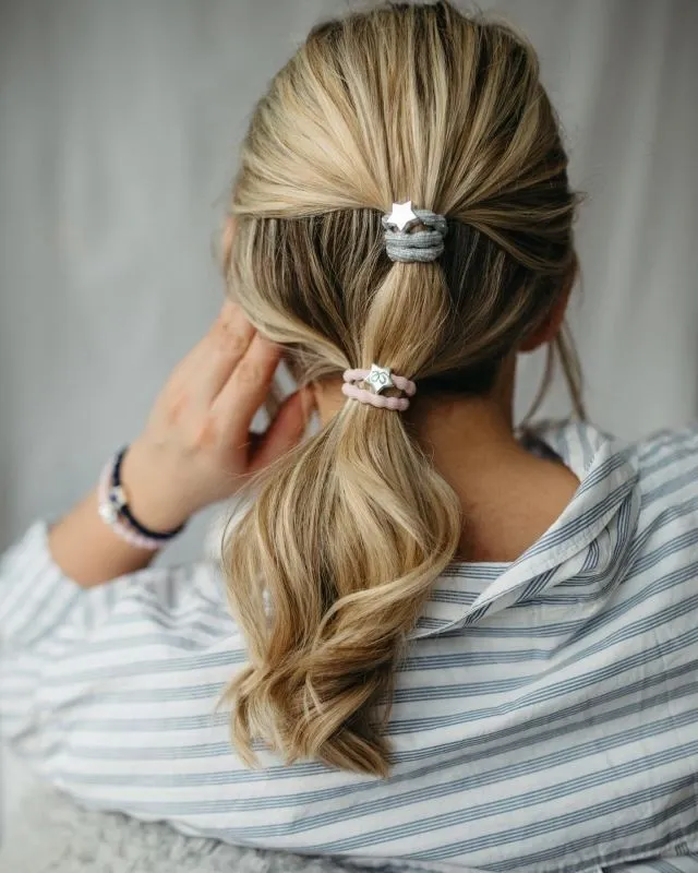 BYELOISE HÅRSTRIKK/ARMBÅND METALLISK SØLVSTJERNE LYSEBLÅT OG ROSA PÅ EN MODELLS HÅR