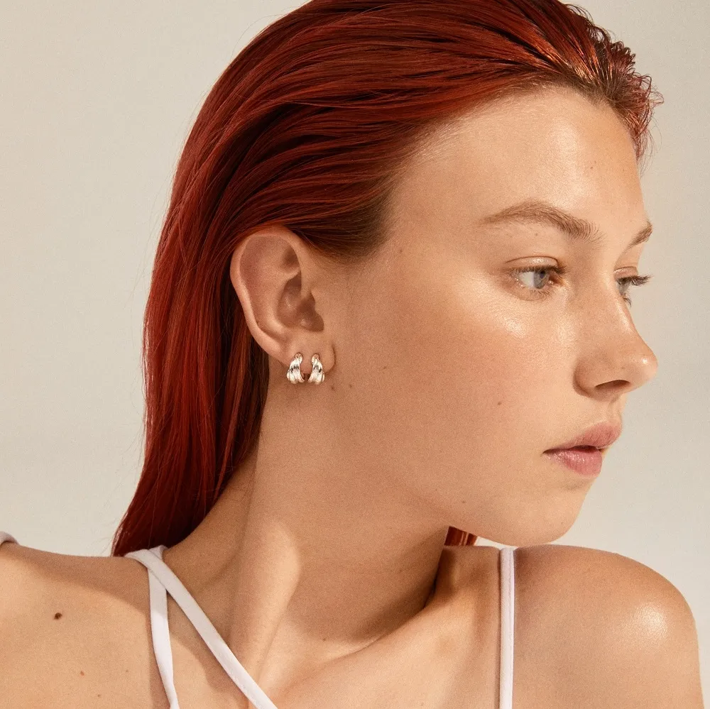 PILGRIM COURAGEOUS HUGGIE HOOP EARRINGS SILVERPLATED PÅ EN MODELLS ØRE