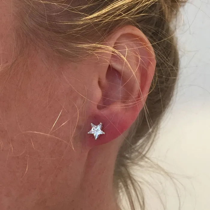JBX ESSENTIAL CRYSTAL STAR STUD EARRINGS PÅ EN MODELLS ØRE